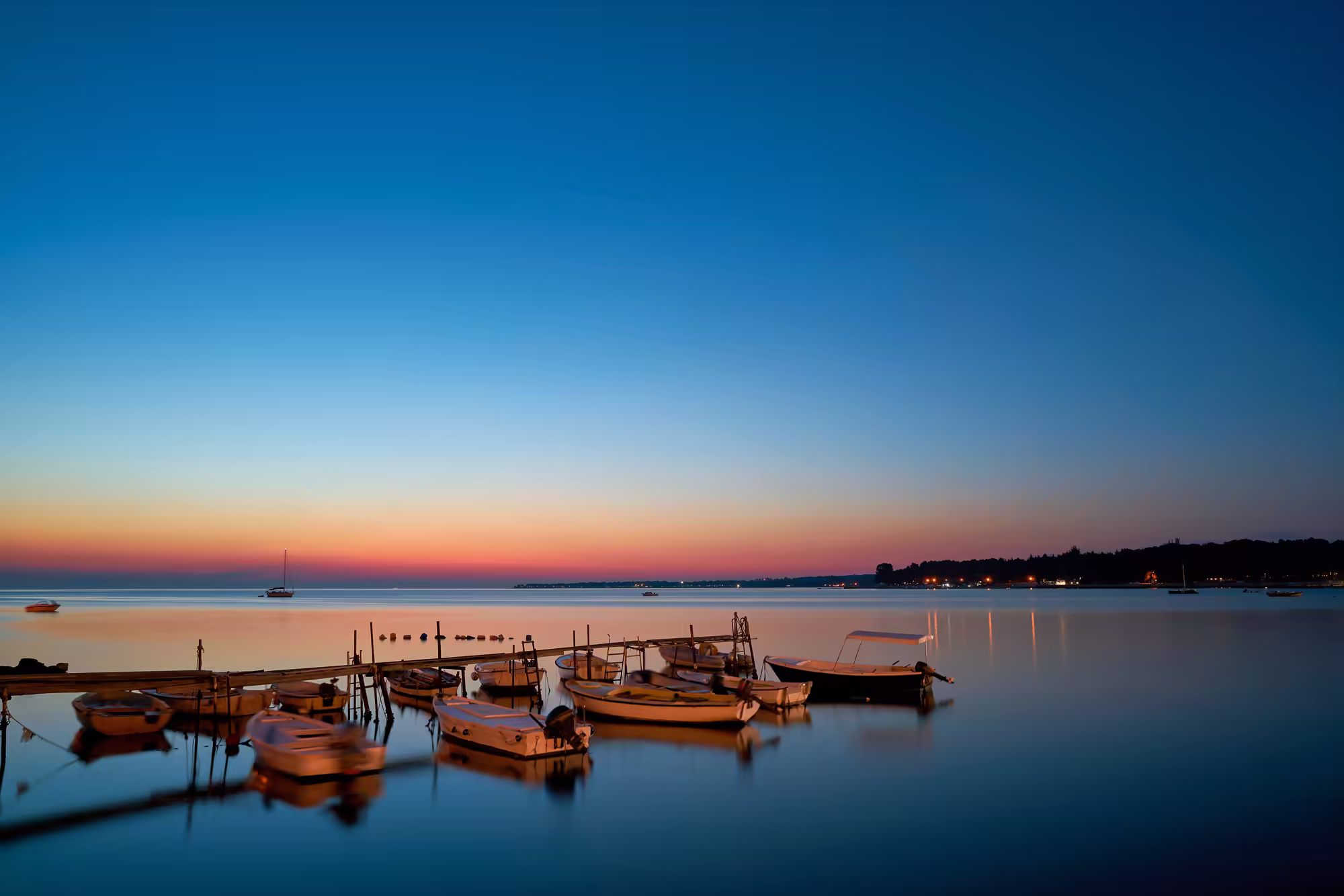 Quiet lagoon with moored boats at dusk