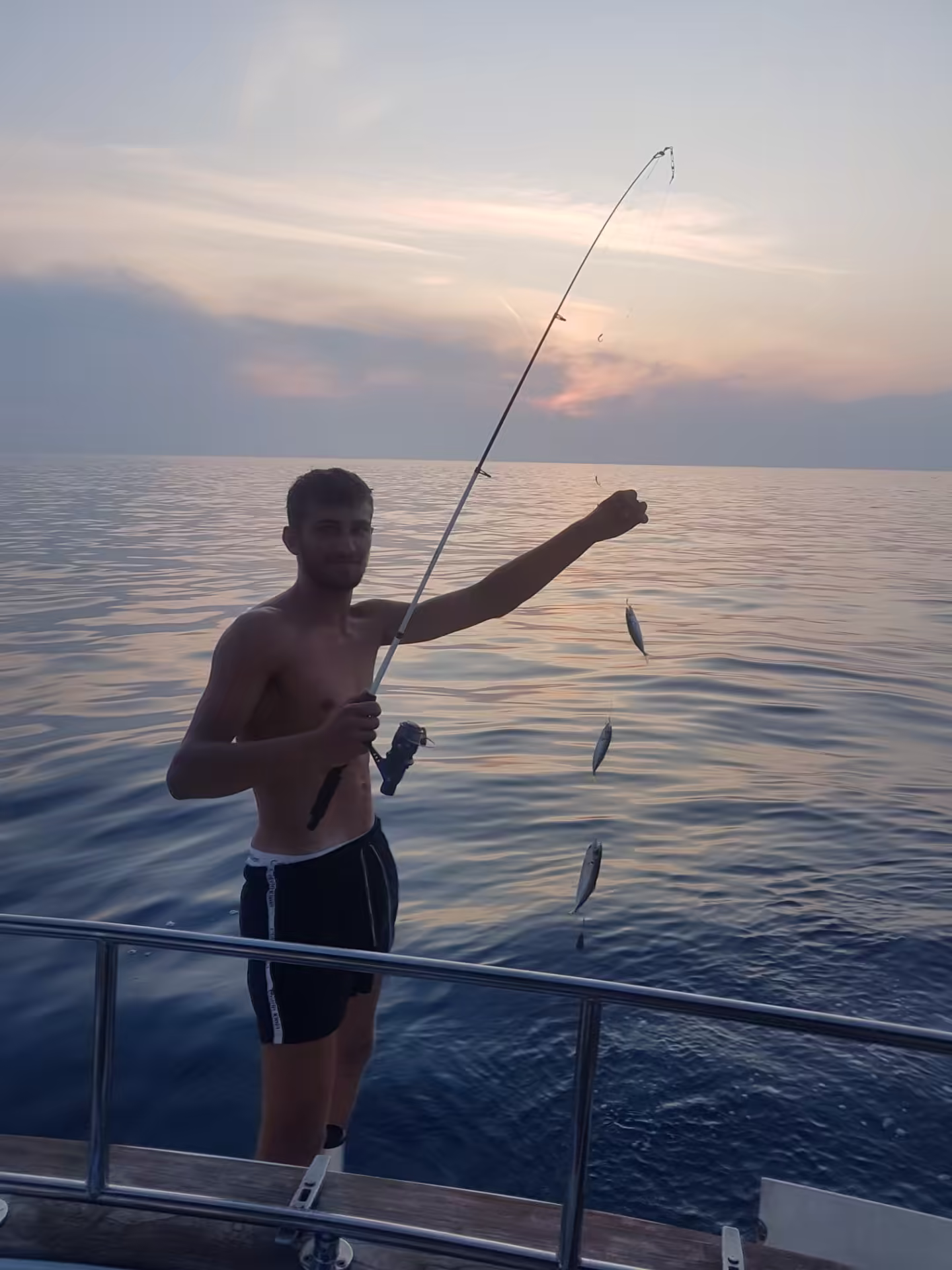 Angler with multiple fish on the line at dusk