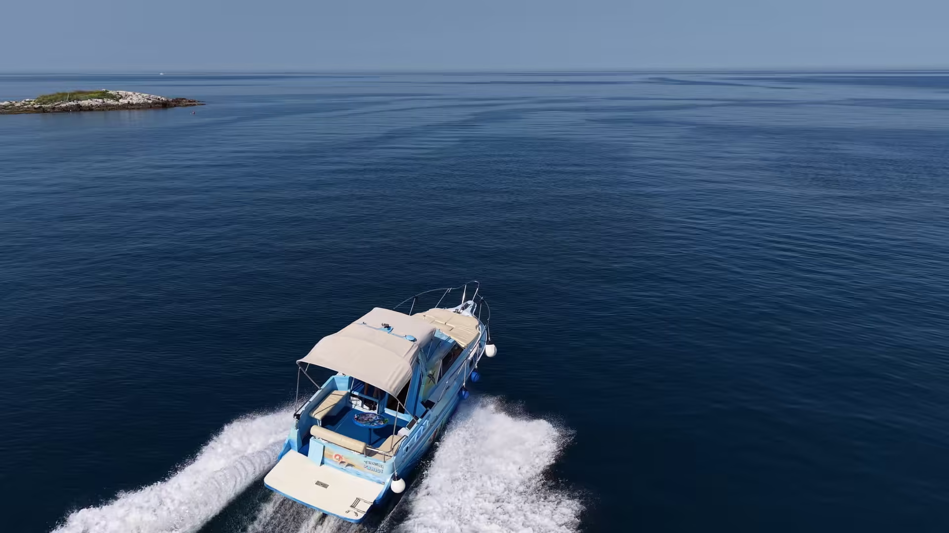 Aerial view of the boat cruising past a wild islet