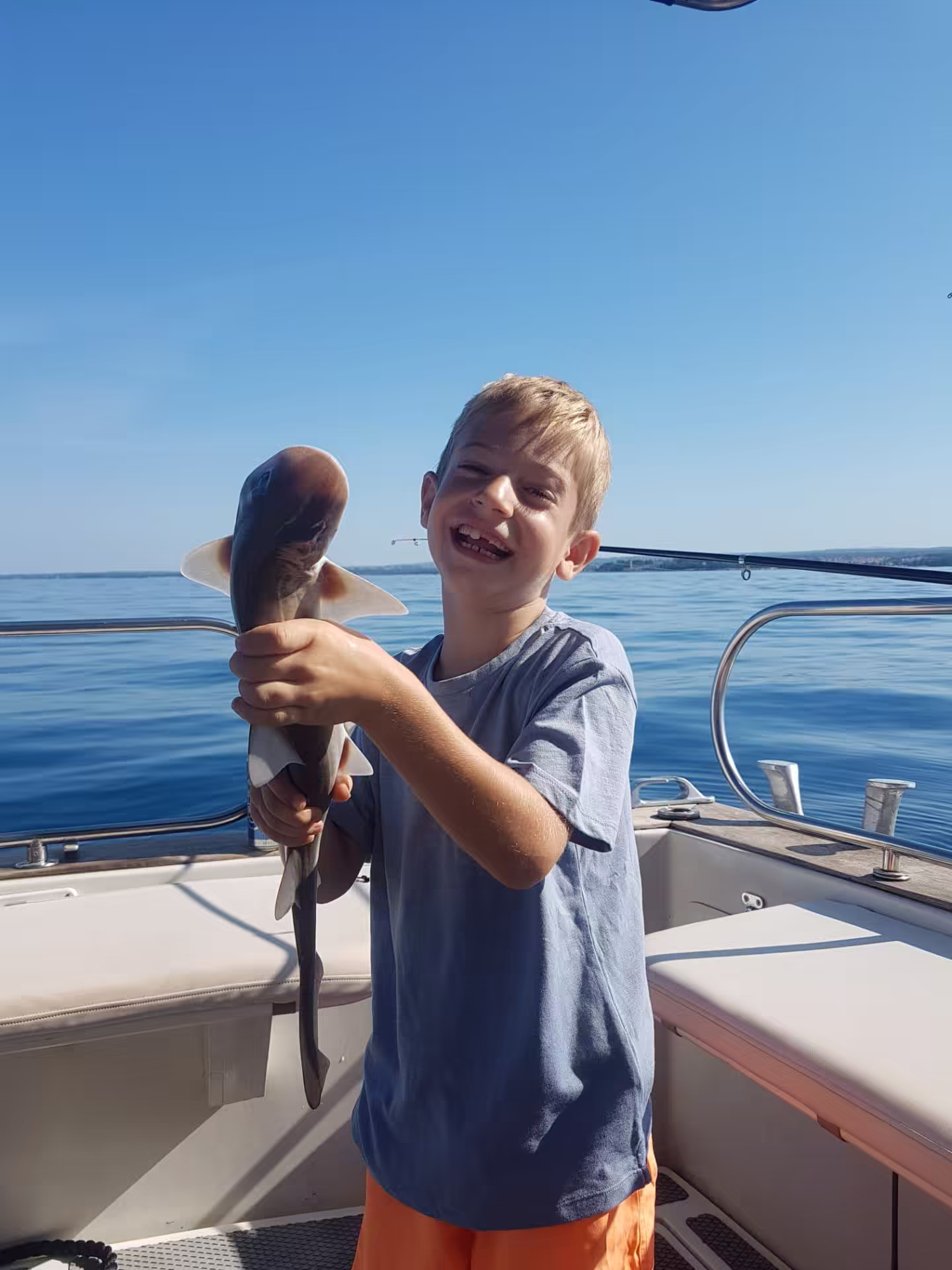 Laughing kid with a small shark catch